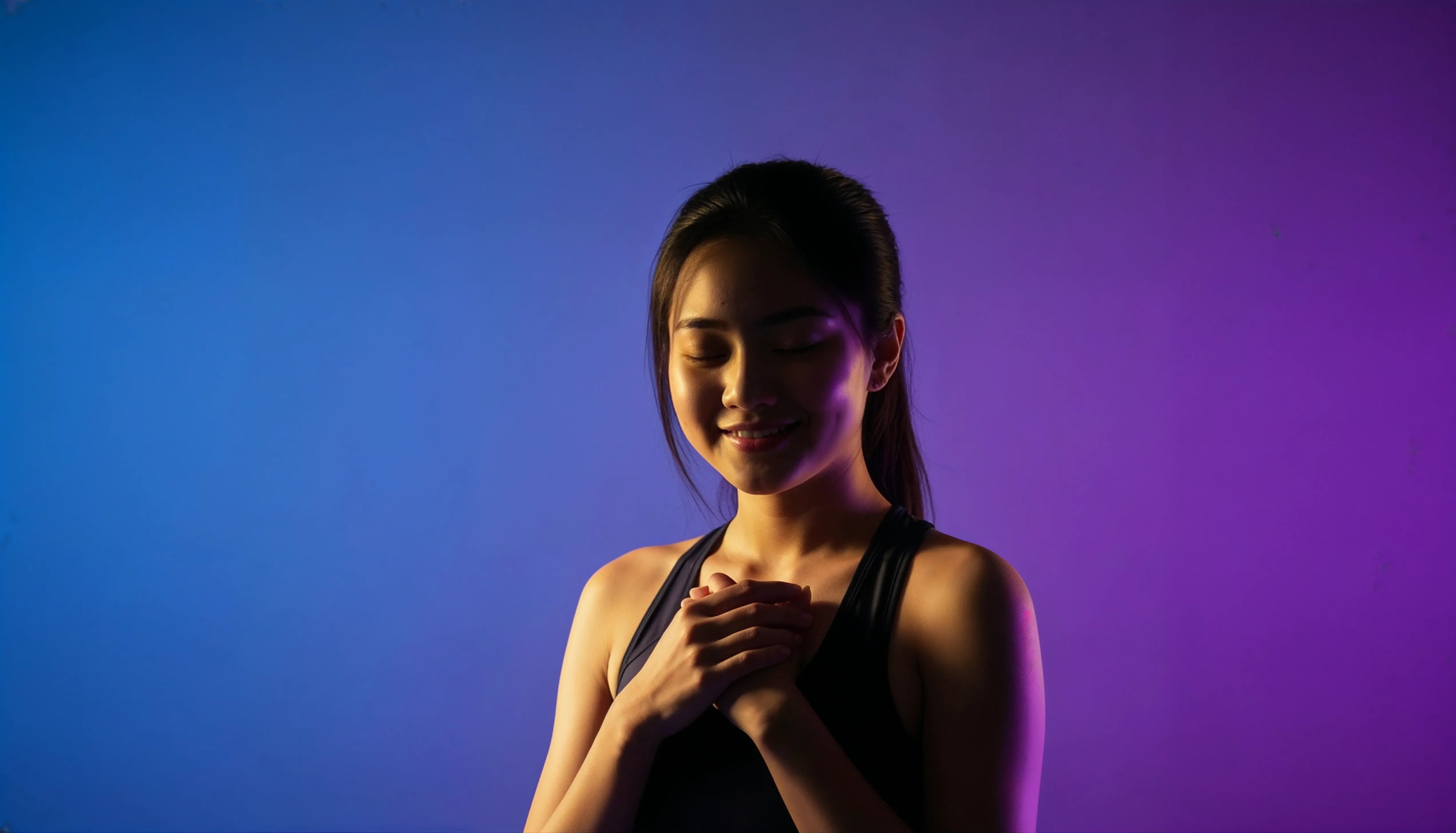 Woman with eyes closed, hands resting on her heart